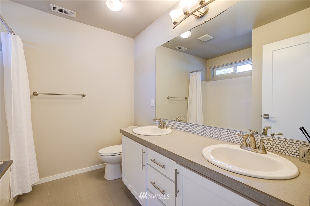 4792 Smithers Avenue South Renton, WA 98055 - Photo 31 of 37 a bathroom with a granite countertop sink toilet a large mirror and shower