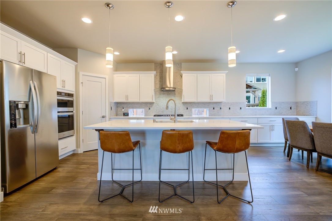 4792 Smithers Avenue South Renton, WA 98055 - Photo 8 of 37 a kitchen with stainless steel appliances granite countertop a refrigerator a sink a stove a dining table and chairs