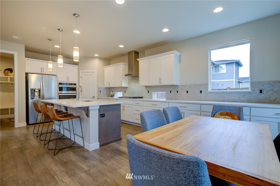 4792 Smithers Avenue South Renton, WA 98055 - Photo 10 of 37 a kitchen with stainless steel appliances kitchen island granite countertop a sink and a refrigerator