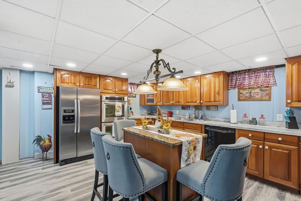 20 Old Orchard Road Wilbraham, MA 01095 - Photo 29 of 40 a dining hall with stainless steel appliances granite countertop a sink a stove a refrigerator cabinets and chairs