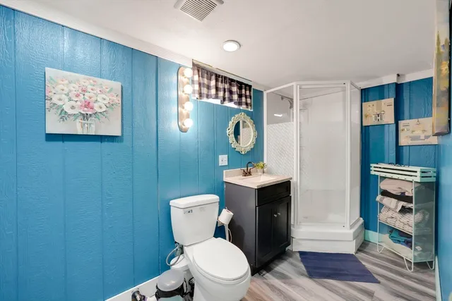 a white toilet sitting next to a bathroom sink and a mirror