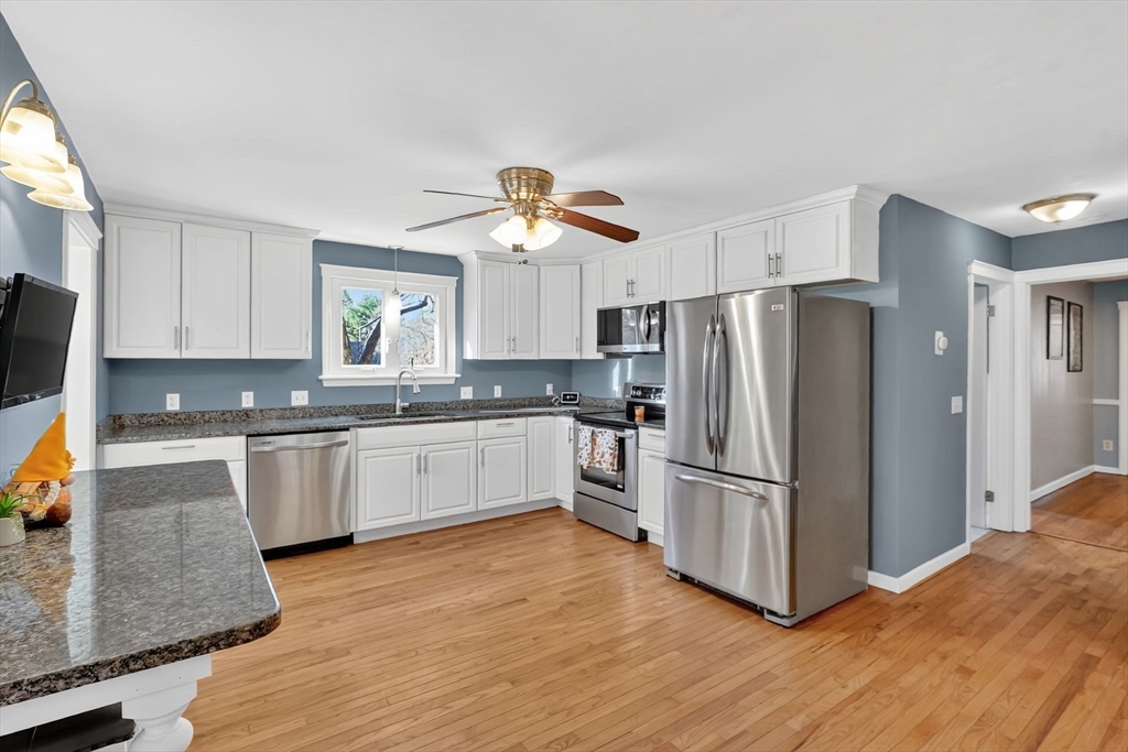 20 Old Orchard Road Wilbraham, MA 01095 - Photo 4 of 40 a kitchen with stainless steel appliances granite countertop a refrigerator a stove a sink and white cabinets with wooden floor