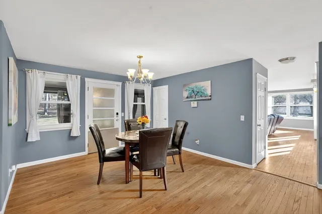 a view of a dining room with furniture a chandelier and wooden floor