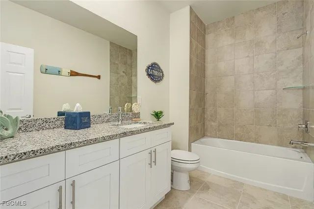 a bathroom with a granite countertop sink a toilet and bathtub