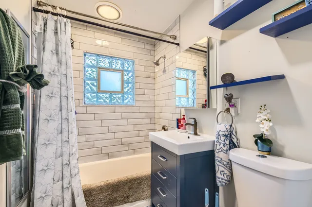a bathroom with a bathtub sink mirror and toilet