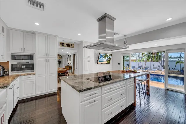 a kitchen with stainless steel appliances granite countertop a stove and a wooden floors