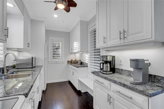a kitchen with granite countertop a sink stainless steel appliances and cabinets