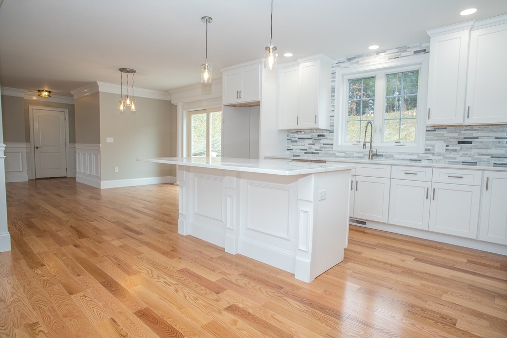 49 Spectacle Hill Road Bolton, MA 01740 - Photo 14 of 42 a large kitchen with granite countertop a stove a sink and white cabinets with wooden floor