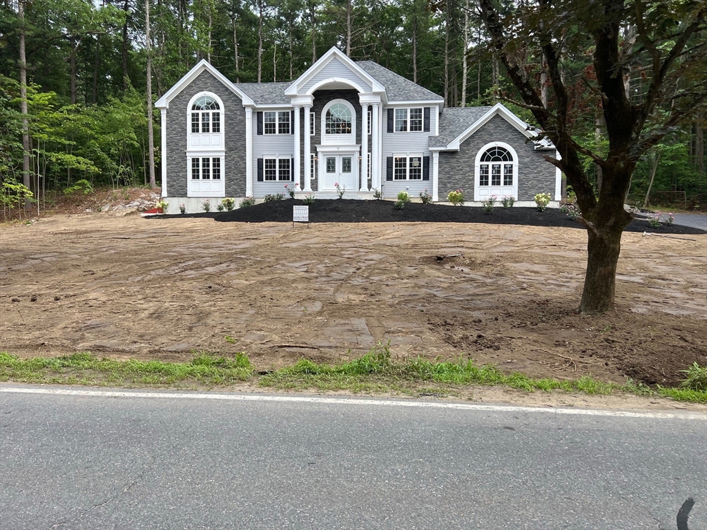 49 Spectacle Hill Road Bolton, MA 01740 - Photo 4 of 42 a front view of a house with a yard and garage