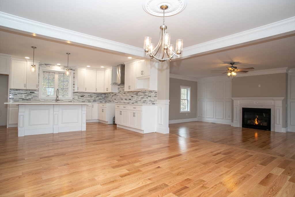 49 Spectacle Hill Road Bolton, MA 01740 - Photo 5 of 42 a view of a kitchen with a chandelier wooden floor and a kitchen