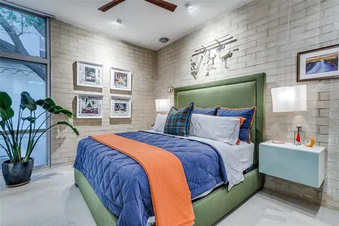 a bedroom with a large bed and a potted plant