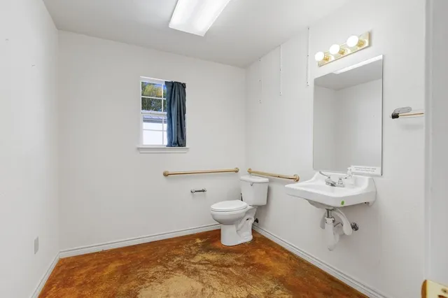 a bathroom with a sink toilet and mirror