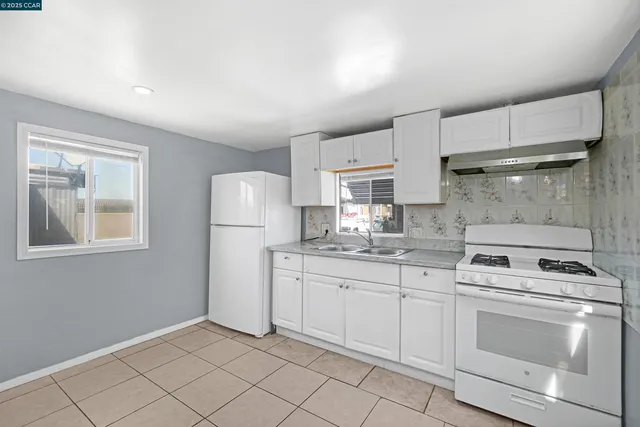 a kitchen with white cabinets and white appliances