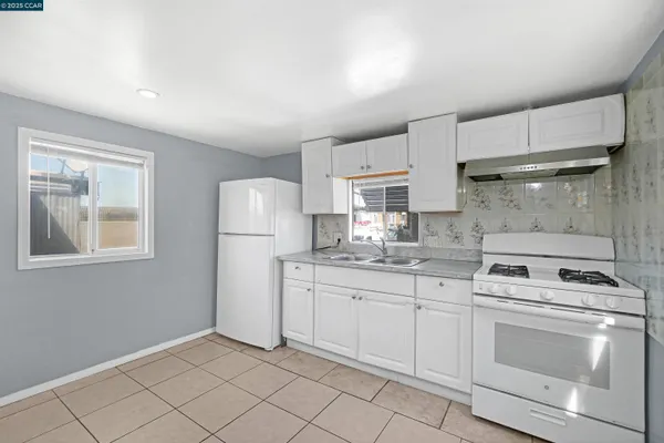 a kitchen with white cabinets and white appliances
