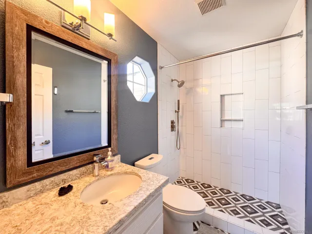 a bathroom with a granite countertop sink toilet and shower