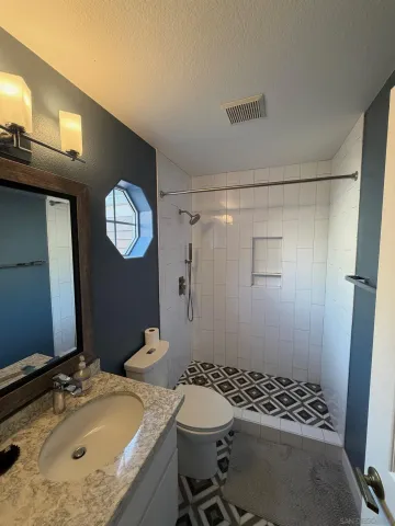 a bathroom with a sink a toilet and shower