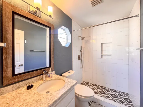 a bathroom with a granite countertop sink toilet and shower