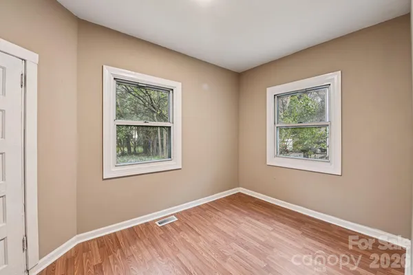 a view of empty room with windows and fireplace