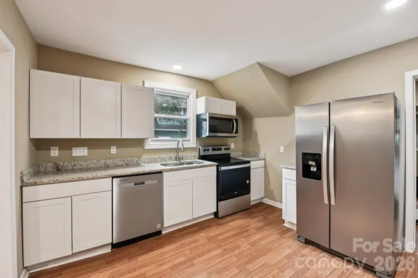 a kitchen with stainless steel appliances granite countertop a stove and a sink
