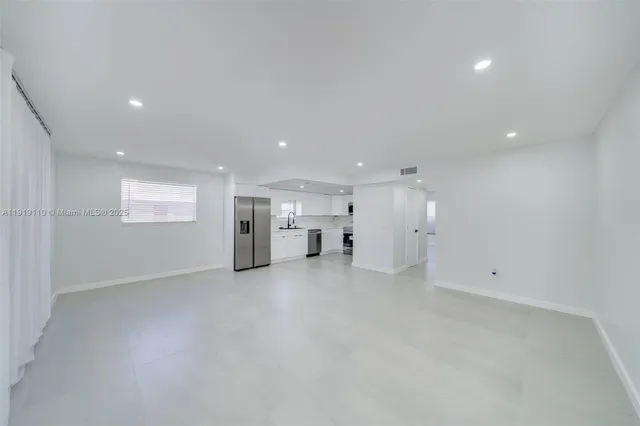 an empty room with a window and fireplace