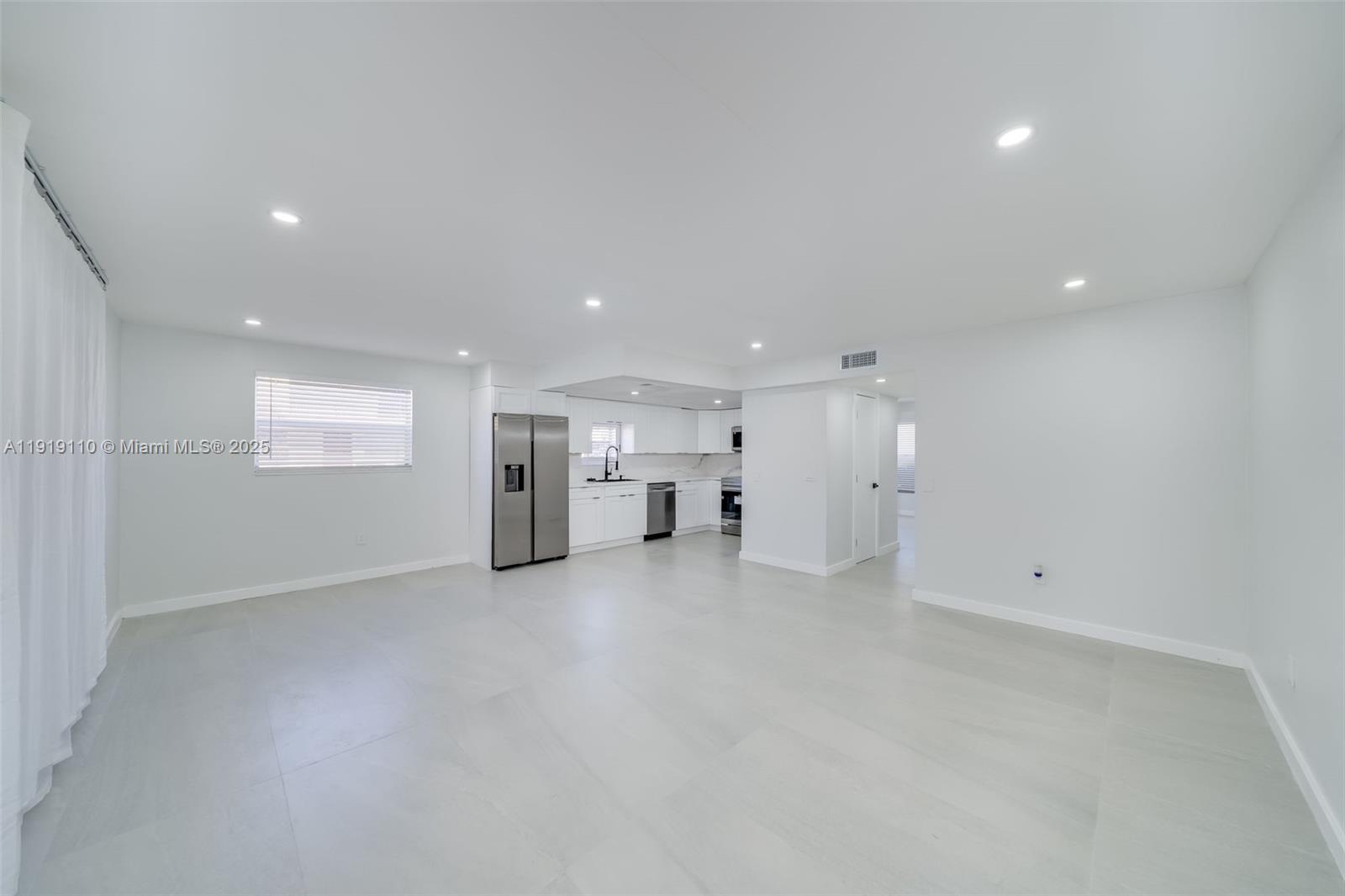 an empty room with a window and fireplace