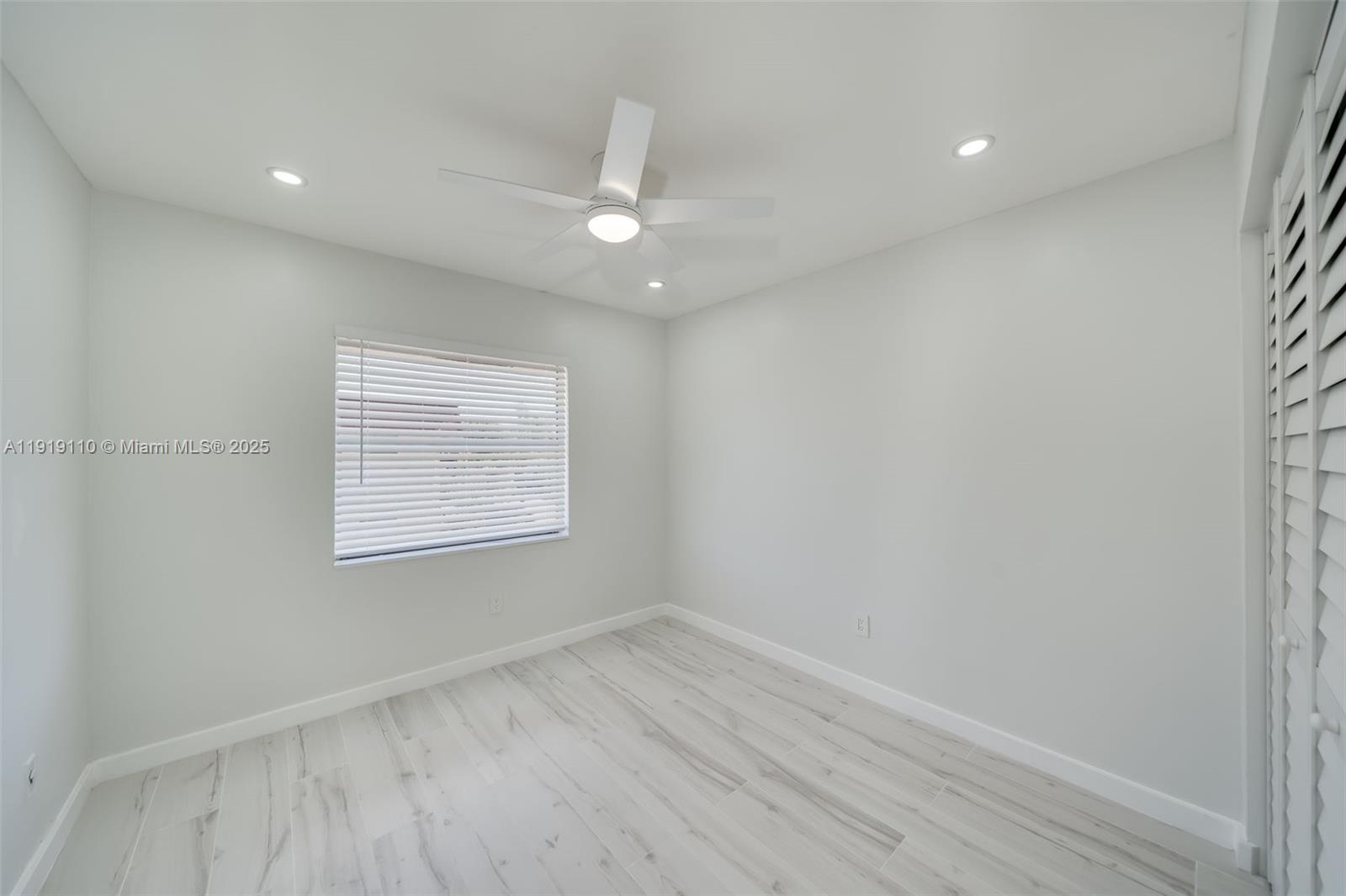 4155 Southwest 66th Terrace, Unit 104 Davie, FL 33314 - Photo 12 of 25 an empty room with wooden floor fan and window