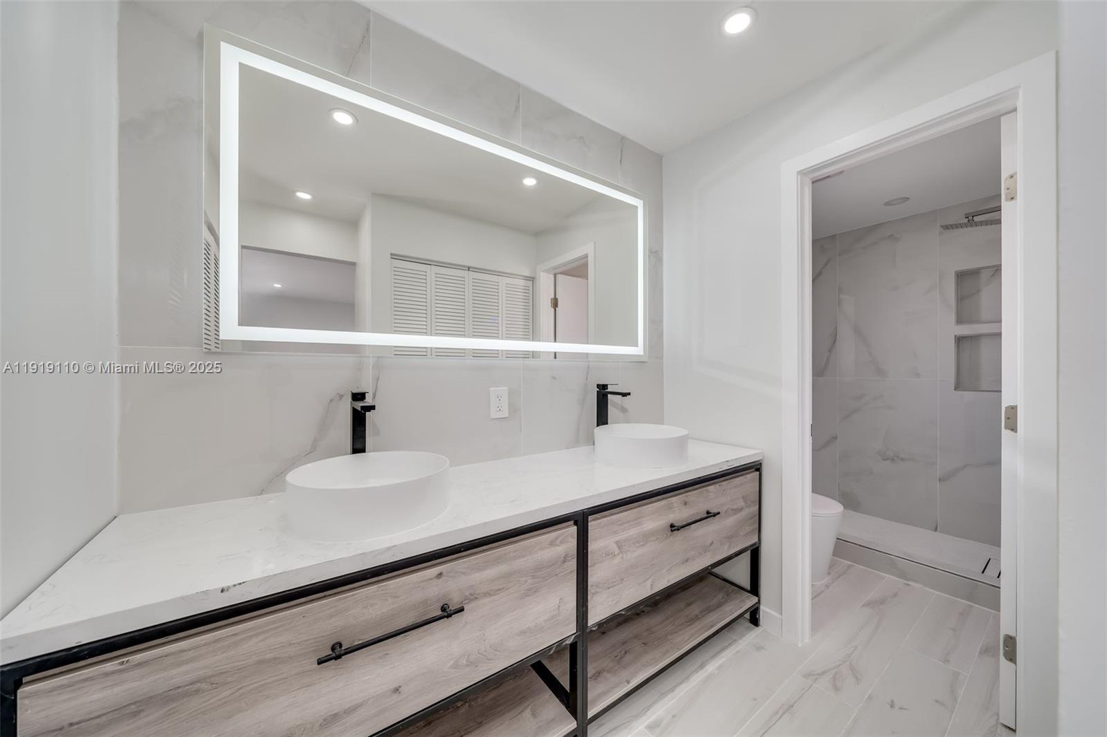 4155 Southwest 66th Terrace, Unit 104 Davie, FL 33314 - Photo 4 of 25 a bathroom with a sink a double vanity and a mirror