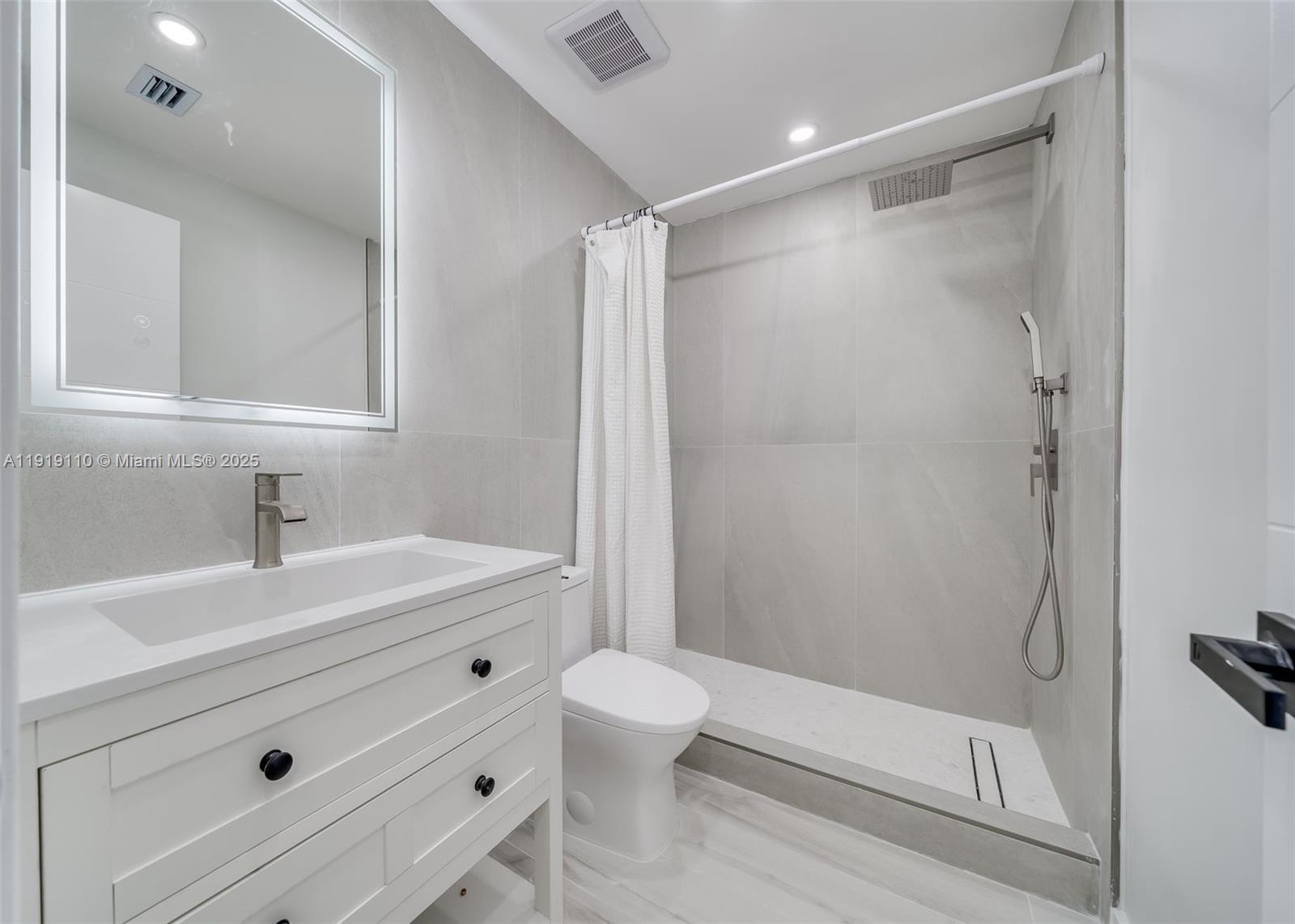 4155 Southwest 66th Terrace, Unit 104 Davie, FL 33314 - Photo 10 of 25 a bathroom with a sink a toilet and a mirror