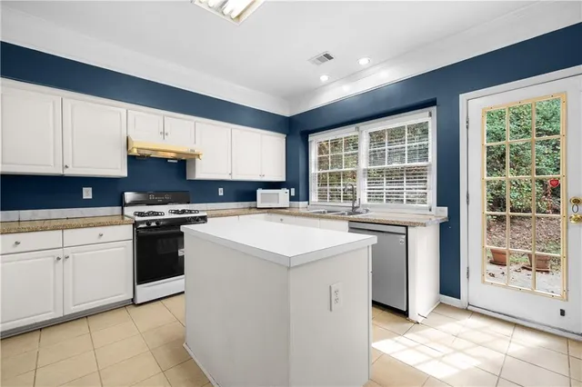 a kitchen with stainless steel appliances granite countertop a stove and a refrigerator