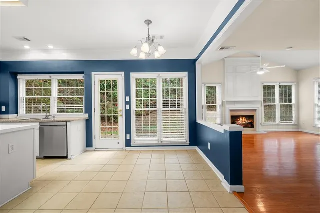 a view of an empty room with wooden floor and a kitchen