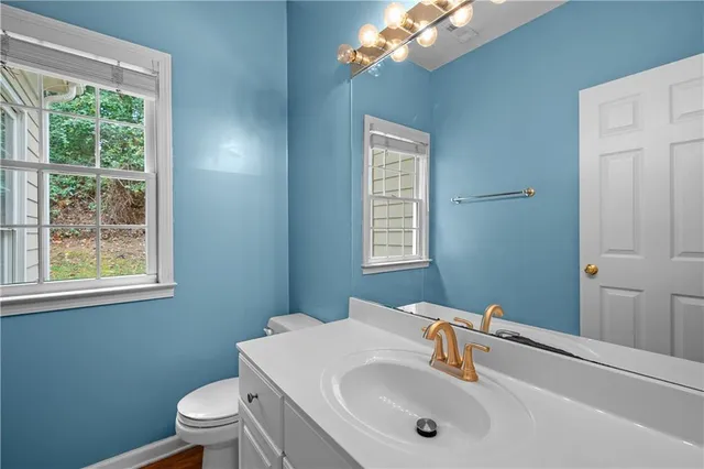 a bathroom with a sink a toilet and a mirror