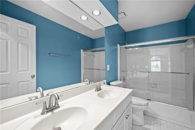 a bathroom with a granite countertop sink a toilet and shower