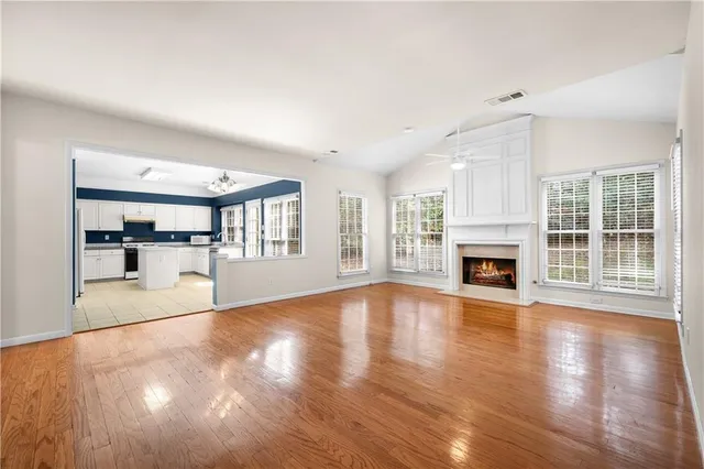 a view of empty room with wooden floor and fireplace