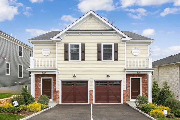 a view of a house with a yard and potted plants