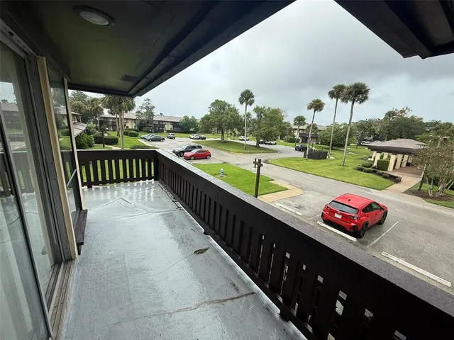 a view of a balcony with cars park
