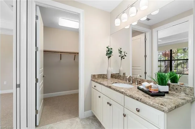 a bathroom with a granite countertop sink a toilet and shower