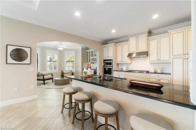 a kitchen with a refrigerator a stove a dining table and chairs with wooden floor