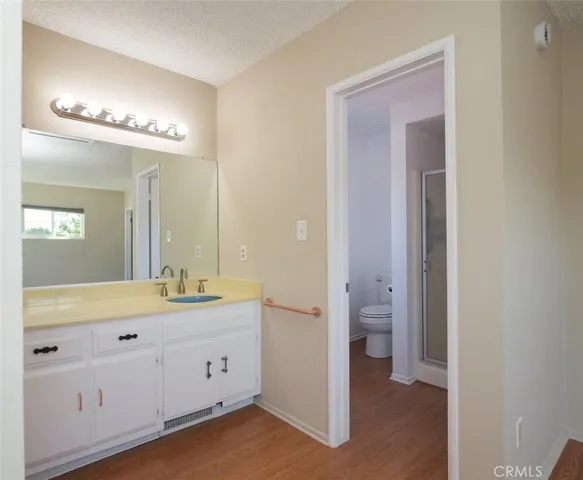 a spacious bathroom with a double vanity sink a toilet and a mirror