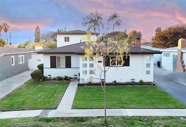 a front view of a house with a garden and plants