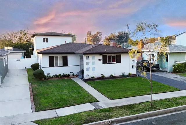a front view of a house with a garden and yard