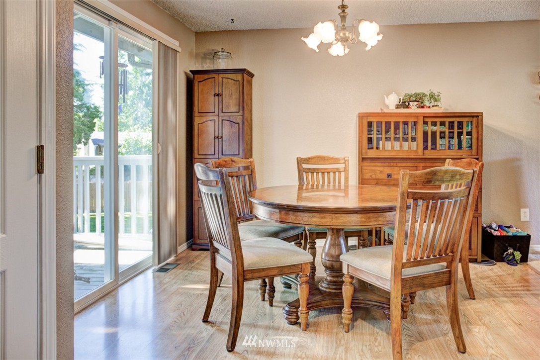 17510 24th Avenue Southeast Bothell, WA 98012 - Photo 11 of 20 a view of a dining room with furniture a chandelier and wooden floor