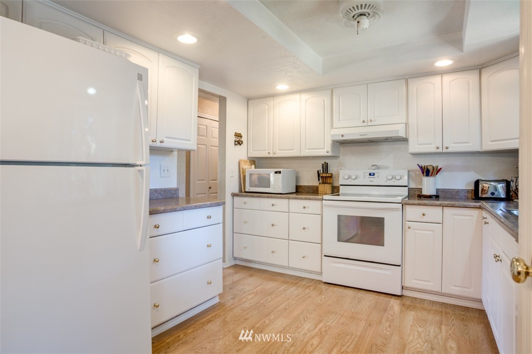 17510 24th Avenue Southeast Bothell, WA 98012 - Photo 7 of 20 a kitchen with white cabinets and white appliances