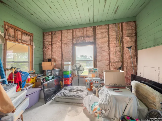 a bedroom with furniture and a large window