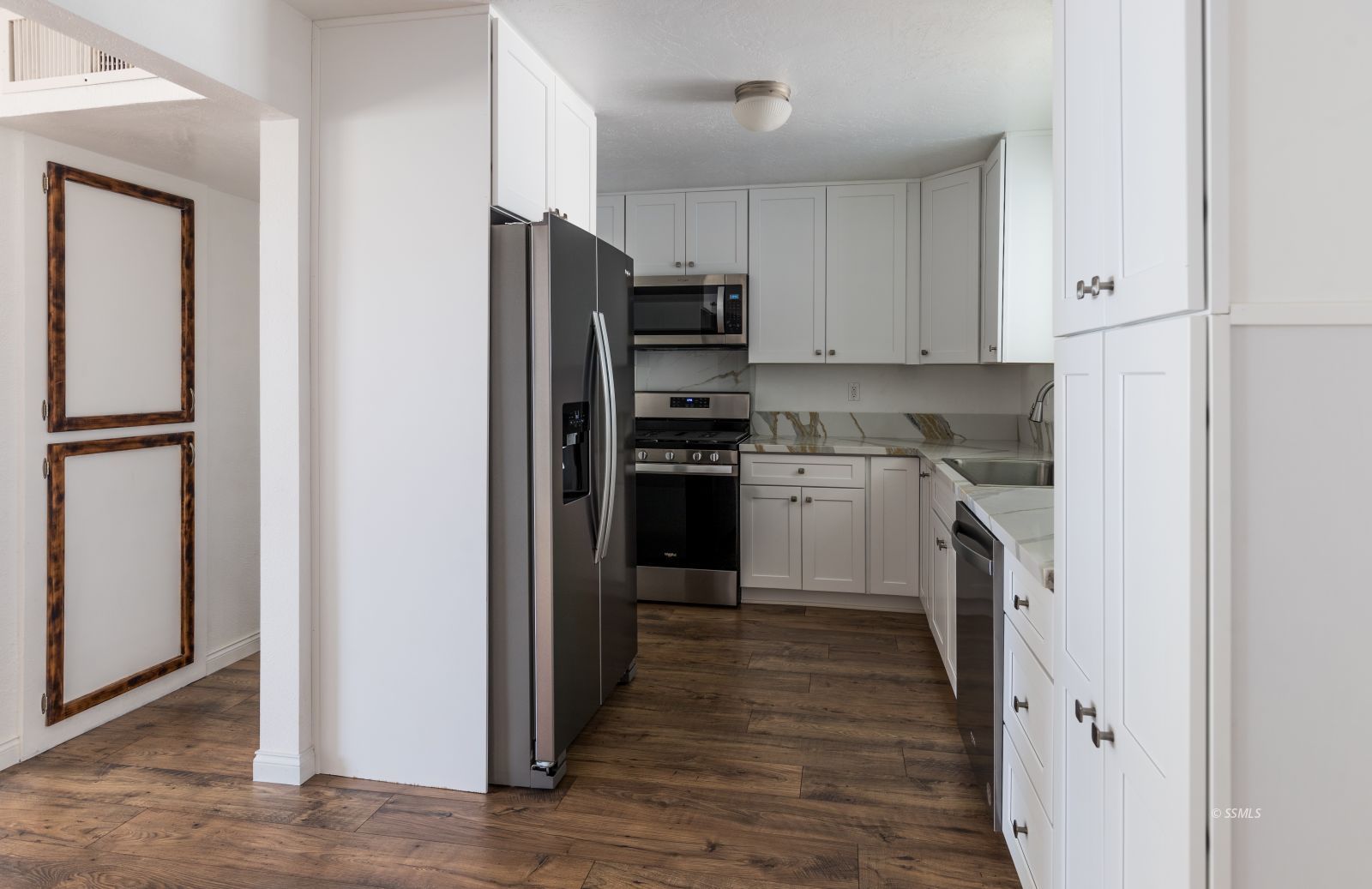 927 West Sullivan Avenue Ridgecrest, CA 93555 - Photo 9 of 24 a kitchen with white cabinets and stainless steel appliances