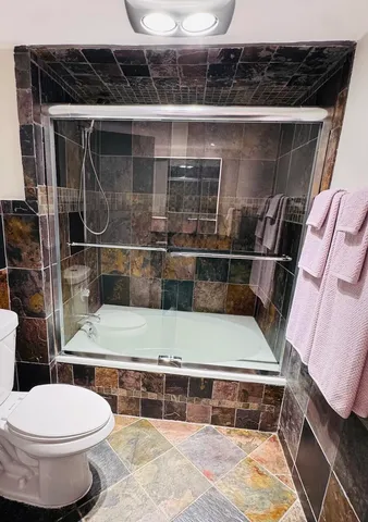 a view of a hallway with wooden floor and windows