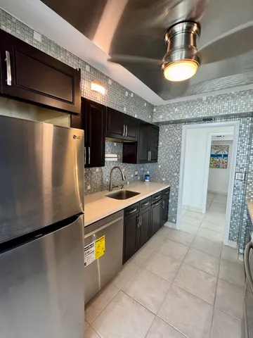 a large kitchen with stainless steel appliances granite countertop a sink refrigerator and microwave