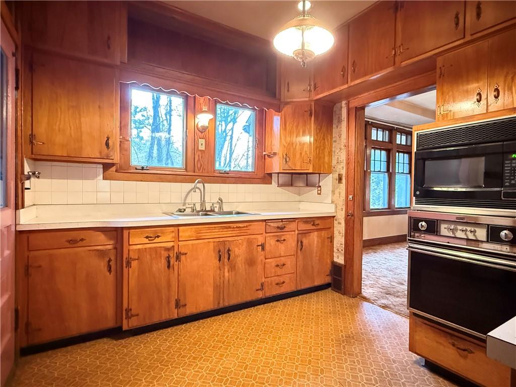 729 East Lake Road Transfer, PA 16154 - Photo 31 of 50 a kitchen with stainless steel appliances granite countertop a sink a stove and a microwave oven