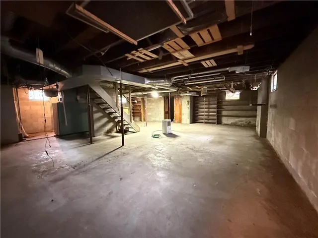 a room with exposed pipes and a window