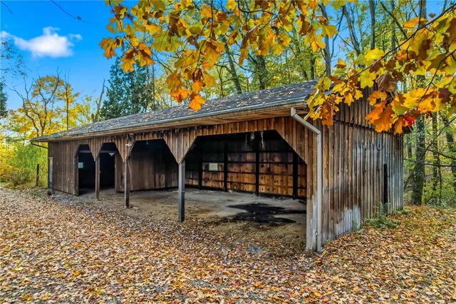 a view of a house with a tree and wooden fence