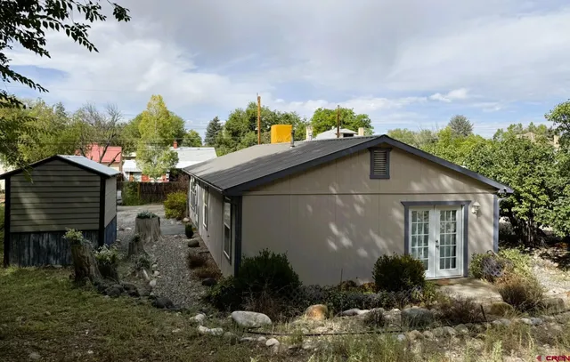 a front view of house with yard and trees around